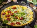 Pyszny omlet na słono z kawałkami chorizo i niebieskim serem, posypany szczypiorkiem i natką pietruszki.
