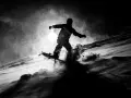 Une silhouette de snowboarder en plein saut, projetant de la neige. L'image, une peinture sur toile noire, capture l'énergie du mouvement dans un style dramatique.