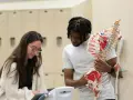 Zwei Studierende lernen Anatomie. Sie diskutieren, wo sie ihr Praktikum machen sollen, während sie ein Skelettmodell betrachten.