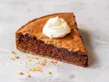 En bit kladdig protein kladdkaka med en klick vispad grädde.