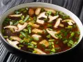 A miska zupy miso z kawałkami tofu, grzybami shiitake i szczypiorkiem.