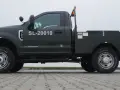 Ciemnozielony Ford F350 z zabudową typu "flatbed" i numerem SL-20010. Solidna maszyna gotowa do pracy.