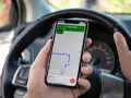 Dłoń trzyma telefon z nawigacją pokazującą trasę do Sarıhasanlı Cd. Czas dojazdu 19 minut. Ile punktów za telefon?