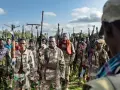 Grupa uzbrojonych mężczyzn, być może bojowników z okolic przylądka Hafun, pozuje do zdjęcia z karabinami.