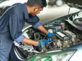Mechaniker arbeitet am Motor. Er prüft die Kraftstoffpumpe, um die Kraftstoffpumpe Kosten zu ermitteln.