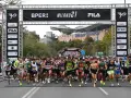 Corredores listos para la media maratón Milán 2021. La carrera arranca bajo un arco con patrocinadores y el logo de Fila.