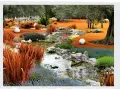Ein malerischer asiatischer Garten mit einem Bachlauf, orangefarbenem Gras, blauem und gelbem Blütenteppich, Steinen und weißen Kugeln.