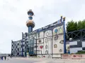 Kolorowy budynek spalarni śmieci Spittelau w Wiedniu z charakterystycznym kominem.