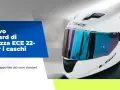 Casco bianco con visiera blu riflettente, simbolo del nuovo standard di sicurezza ECE 22-06 per i caschi.