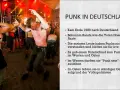 Junge Männer tanzen ausgelassen zu Punk-Songs auf einem Festival. Die Szene zeigt die Energie und Rebellion der Punk-Bewegung in Deutschland.