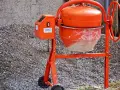 Pomarańczowa betoniarka gotowa do pracy. Z jej pomocą szybko przygotujesz beton B25 na budowę.