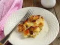 Brotpudding mit Rosinen auf einem Teller mit einer Gabel und einer rosa karierten Serviette.