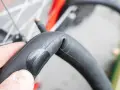 Dłoń trzyma załataną detkę rowerową, gotową do powrotu na swoje miejsce w oponie.