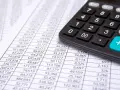 Calculadora sobre hoja de cuentas, mostrando posibles remuneraciones pendientes de pago activo o pasivo.