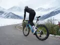 A cyclist rides on a snowy mountain road, proving you can mountain bike in the winter.