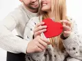 Para, trzymająca czerwone serce, uśmiecha się do ukochanego. To ich test na zakochanie.