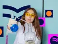 Dziewczyna w okularach ochronnych i białym fartuchu miesza płyny w probówkach. Zastanawia się, co po biol chemie.