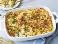 Ein goldbrauner blumenkohl nudel auflauf mit Käse überbacken und frischer Petersilie garniert, bereit zum Servieren.