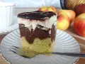 Pyszne ciasto Fale Dunaju z kremem i polewą czekoladową, obok jabłka i filiżanka kawy.