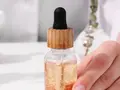 Dłoń trzymająca serum z pipetką. Składniki takie jak EDTA w kosmetykach pomagają stabilizować formuły.