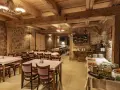 Przytulna restauracja w stylu rustykalnym, z kamiennymi ścianami i drewnianymi belkami. Idealne miejsce na posiłek w twierdzy Srebrna Góra.