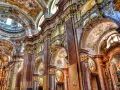 Bogata architektura baroku zachwyca złotymi zdobieniami, marmurowymi kolumnami i freskami na sklepieniach.