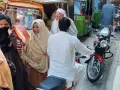 Ludzie na ulicy w Pakistanie, wśród nich kobiety w hidżabach i dzieci. Czy pakistan jest bezpieczny? Tłum na targu, ruchliwa ulica.