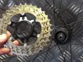 En hand håller en cykelkassett redo att byta ut den på bakhjulet.