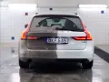 Volvo V90, halvtvättad. En sida är täckt av lera, den andra skiner efter avfettning bil.