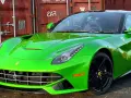 Jaskrawozielone Ferrari F12 Berlinetta z czarnymi felgami, zaparkowane przed czerwonym kontenerem.