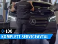 Mekaniker utför service på en Mercedes-Benz skåpbil. Texten "KOMPLETT SERVICEAVTAL" syns.