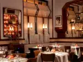 Tavoli apparecchiati in un ambiente elegante, ideale per scoprire i migliori ristoranti Milano. Luci soffuse e dettagli raffinati creano un'atmosfera accogliente.