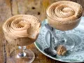 Due coppe di deliziosa mousse al caffè, guarnite a spirale, su un piatto decorato.