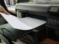 Dłoń wkłada papier do drukarki. To nie jest elementem eksploatacyjnym drukarki laserowej, lecz jej podstawowym materiałem.