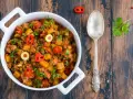 Pyszne danie z mielonego mięsa wołowego z ziemniakami, oliwkami i papryczką chili, posypane natką pietruszki.
