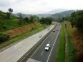 Droga ekspresowa z ruchem samochodów, otoczona zielonymi wzgórzami. Planujesz podróż i zastanawiasz się, jak zapłacić za autostradę A4?