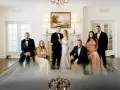Para ślubna i drużba stoją w eleganckim wnętrzu.
