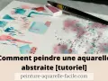 Une peinture abstraite facile à réaliser avec des touches de rose et de bleu. Un pinceau et une palette de couleurs sont visibles.