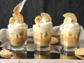 Pyszny deser bananowy przepis w szklaneczkach: warstwy ciastek, karmelu, bananów i bitej śmietany. Idealny na deser!