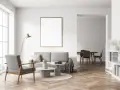 Szary salon z sofą i fotelem w kolorze kaszmirowym, stolikami kawowymi i lampą. W tle widać jadalnię.