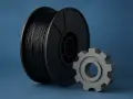 Szpula czarnego filamentu ABS i szare koło zębate. Materiał ABS ma wysoką temperaturę mięknienia, co czyni go idealnym do druku 3D.