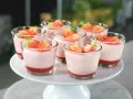 Deliziosi dolci al cucchiaio alla fragola, serviti in bicchierini trasparenti e guarniti con fragole fresche.