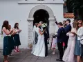Para młoda całuje się przed kościołem, goście sypią bańki mydlane. To piękny ślub jednostronny, pełen radości i miłości.