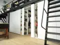 Divisori ambienti interni con librerie a scomparsa, ideali per organizzare e definire spazi in stile moderno.