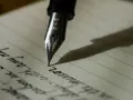 Stalówka pióra wiecznego kreśli słowa na papierze w linie. Zastanawiam się, czy przed "mimo" stawiamy przecinek, pisząc tę myśl.