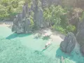 Rajska zatoka na Filipinach z krystalicznie czystą wodą, palmami i łodzią. Idealne miejsce na wakacje na wyspach Filipin.