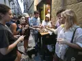 Grupo de amigos disfrutando de tapas en la calle, una escena típica de la hostelería. El IVA de la hostelería no les quita el apetito.