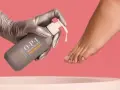Gloved hand dispenses OPI Nature Strong Pedi Soak, preparing to soak feet for a luxurious pedicure.