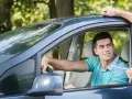 Agente di polizia controlla documenti a un automobilista, forse per la scadenza dell'assicurazione auto.