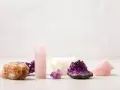 Colección de cristales energéticos: amatista, cuarzo rosa y calcita anaranjada, dispuestos sobre una superficie clara.